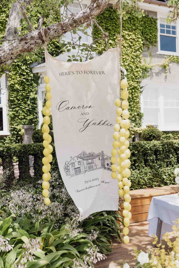 Fruit and draped-fabric welcome sign for Cameron & Yukkie's wedding