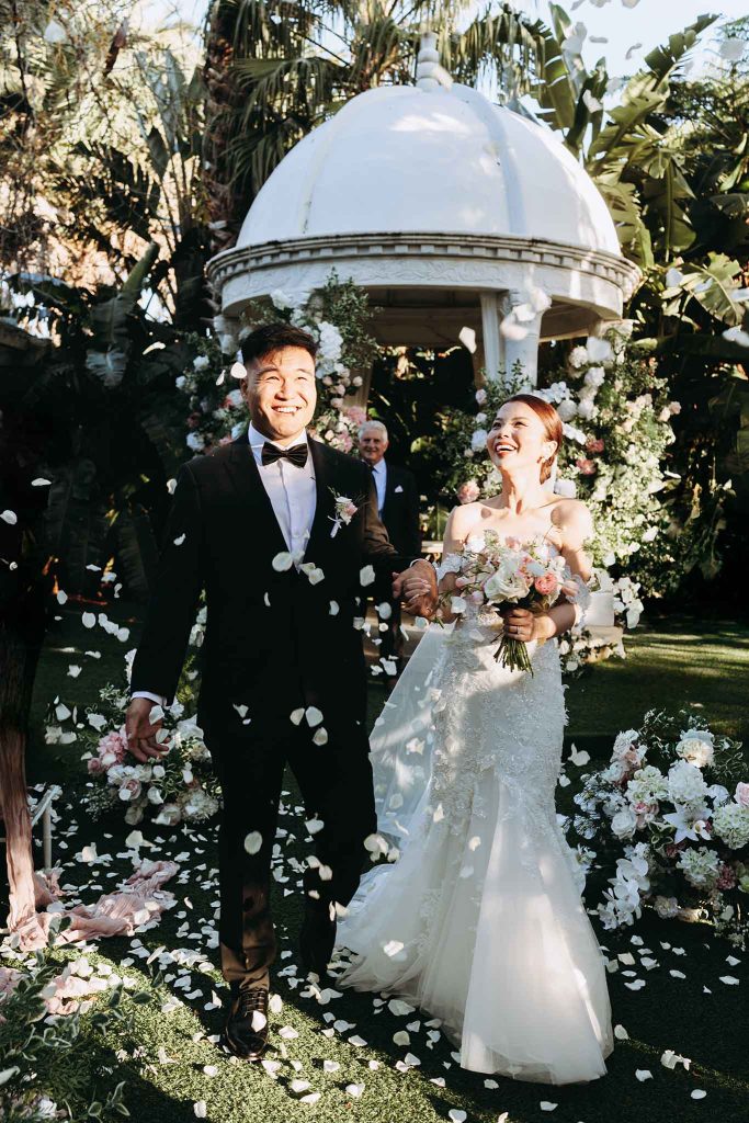 Caly & Yadi's magical ceremony exit beneath cascading petals